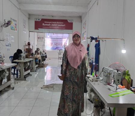 Suci Sustari, pemilik Rumah Jahit Lestari, berpose di tengah para karyawannya yang tengah menjahit (foto/Andy)